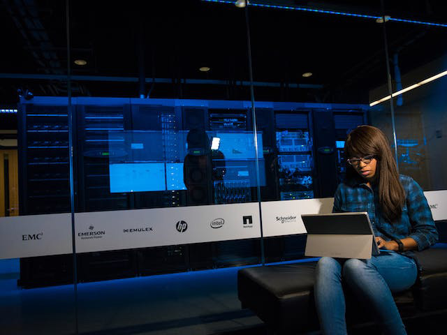 A woman with long hair on a laptop in a computer lab