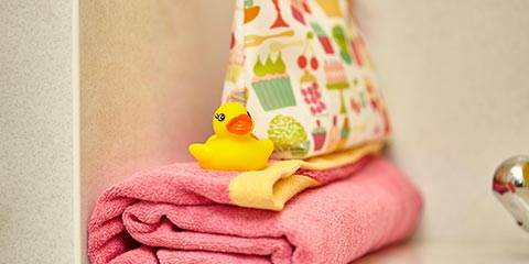 Bathroom towels, lavatory bag and a rubber duck