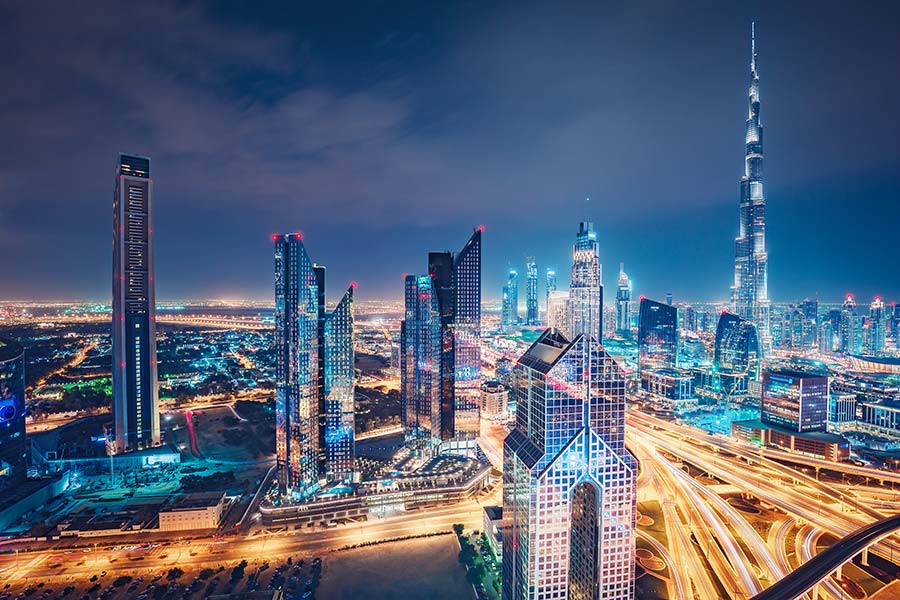 Futuristic view of Dubai skyline at night with light trails.