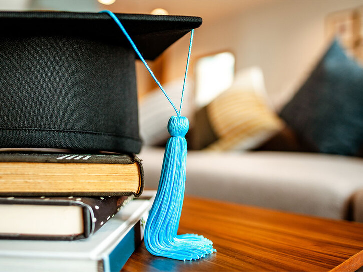 Graduation mortarboard on some books on a coffee table