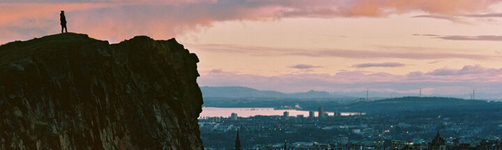 Person on top of a hill overlooking the Edinburgh skyline