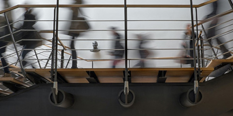 Blurred silhouttes of people walking across a staircase landing