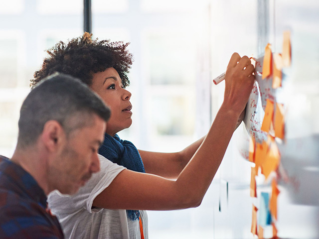 woman brainstorming on a whiteboard