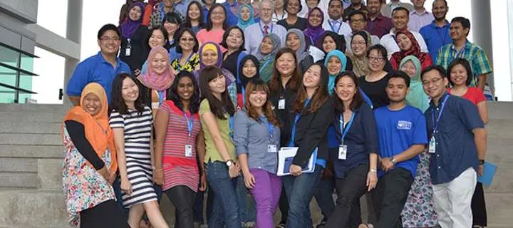 The first staff at the Malaysia Campus form a group on the steps outside the entrance