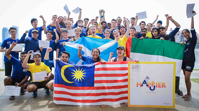 Group of students holding their county flags at the dragon boat race