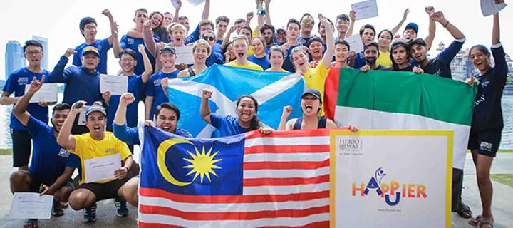 Group of students holding their county flags at the dragon boat race