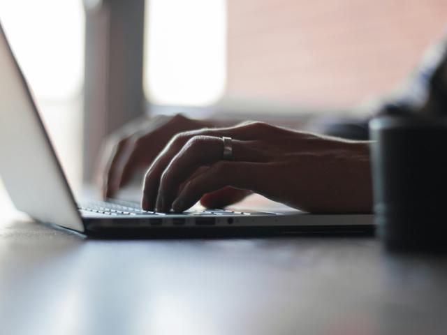 Close up of a person typing on a laptop