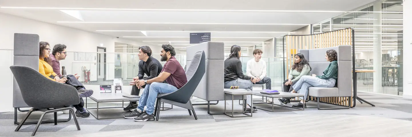 Students seated in the mezzanine floor sofas in the GRID building