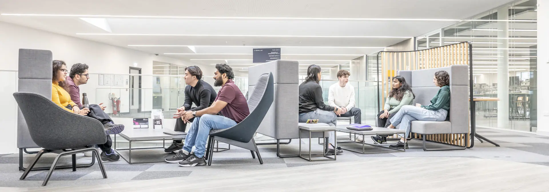 Students seated in the mezzanine floor sofas in the GRID building