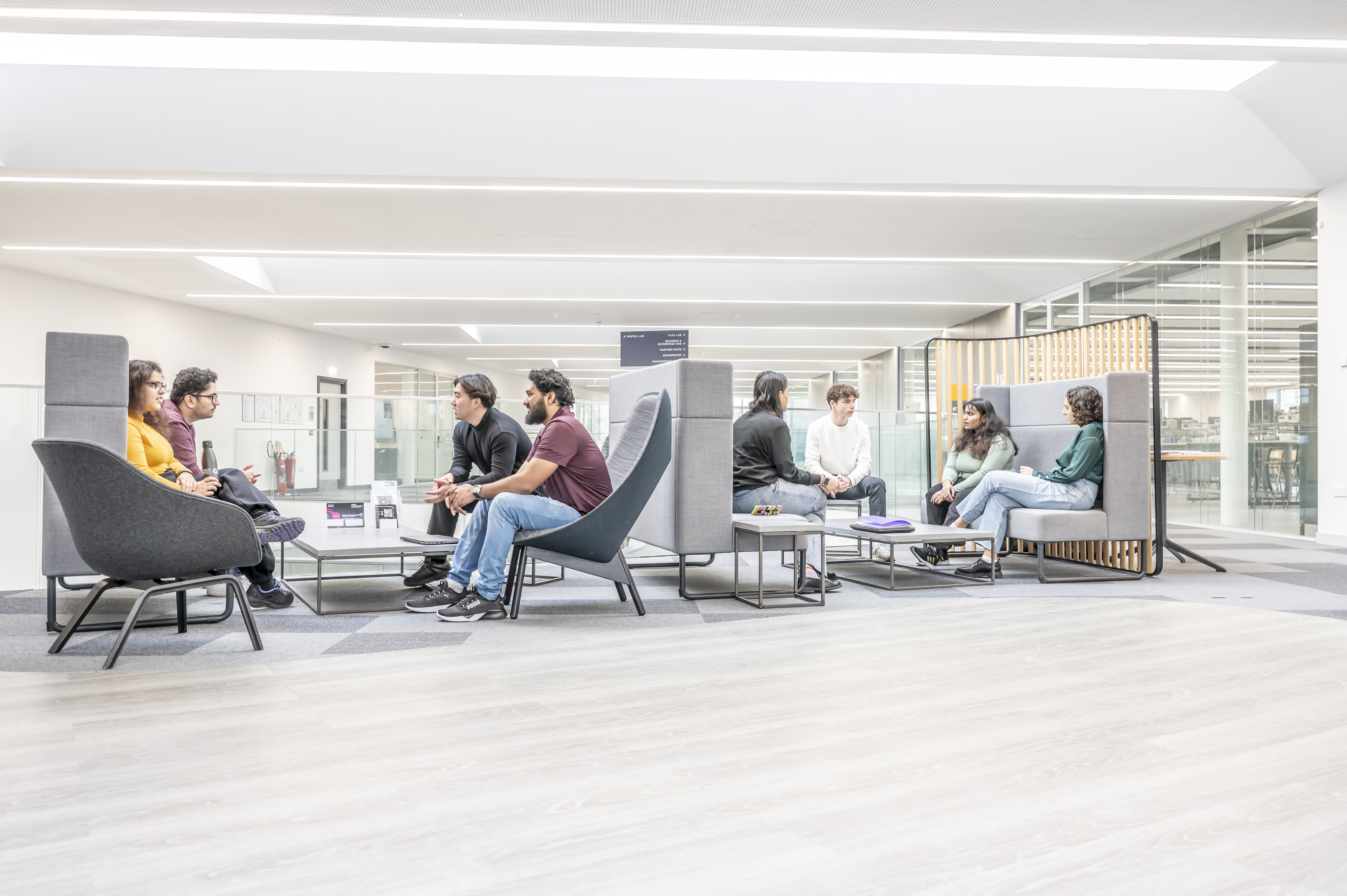 Students seated in the mezzanine floor sofas in the GRID building