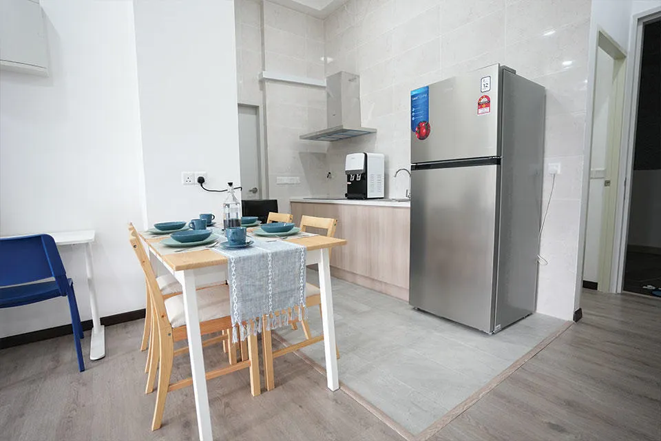 Kitchen and Dining area A compact kitchen featuring a refrigerator, a dining table, and chairs, designed for efficient use of space.