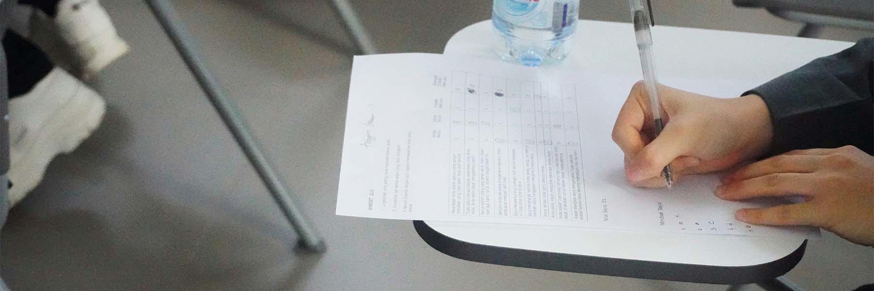 A student writes on an exam paper