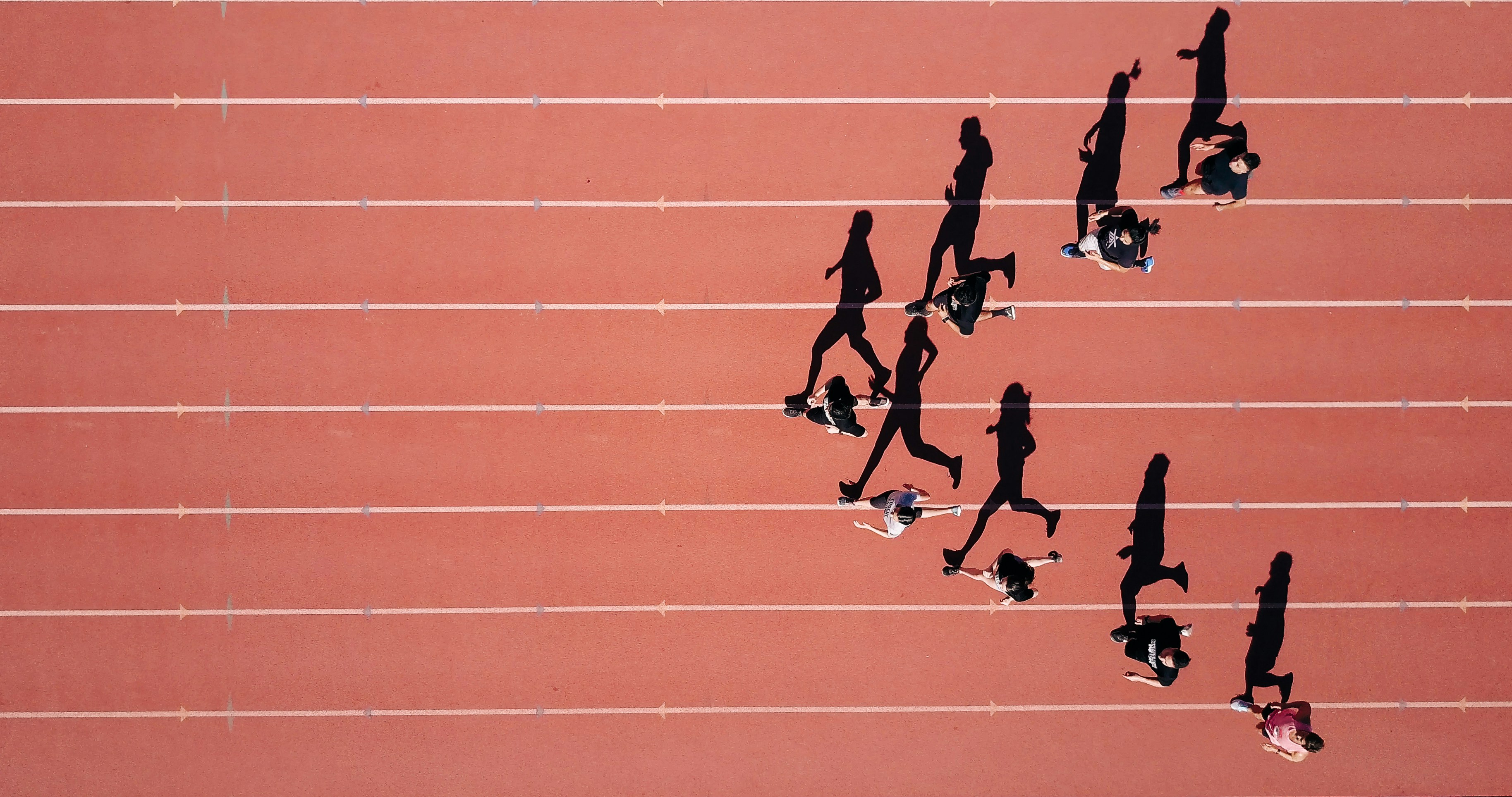 Athletes running in a triangle formation with from an arial view - Photo by Steven Lelham on Unsplash