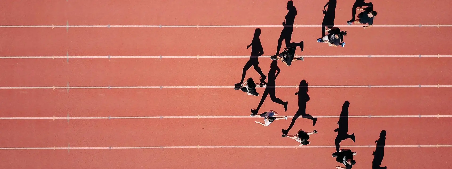 Athletes running in a triangle formation with from an arial view - Photo by Steven Lelham on Unsplash