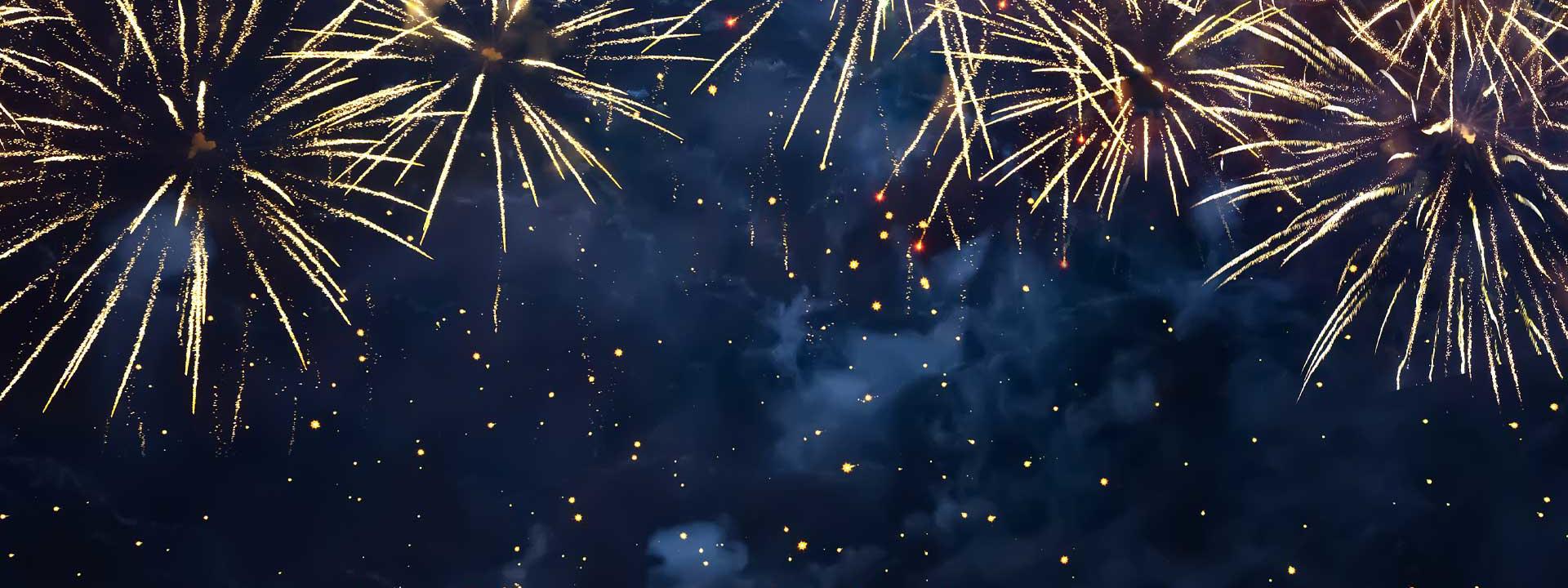A vibrant display of fireworks lights up the dark sky, dotted with shining stars.