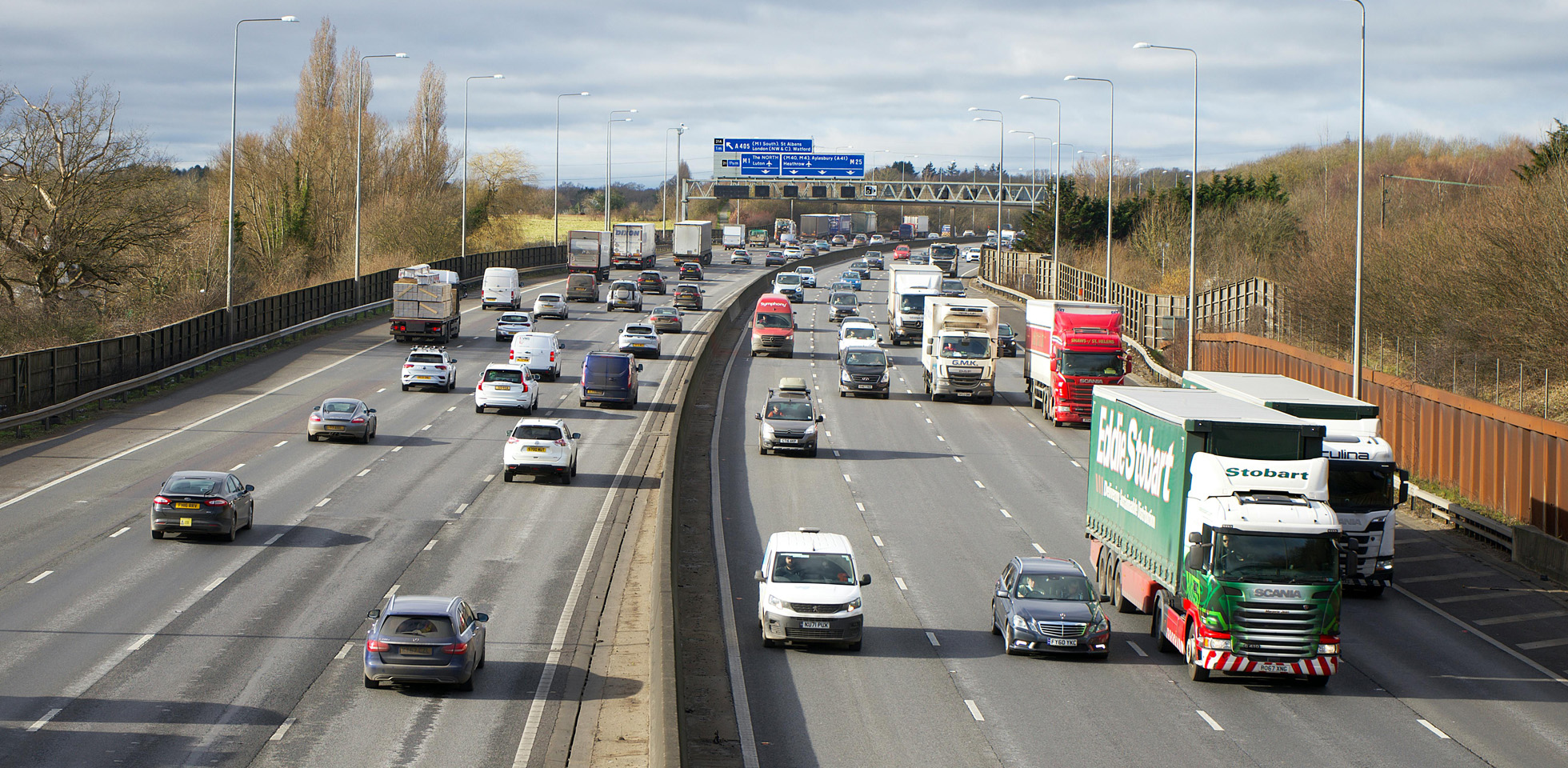 Cars and trucks on a busy motorway. Photo by Mike Bird on Pexels.