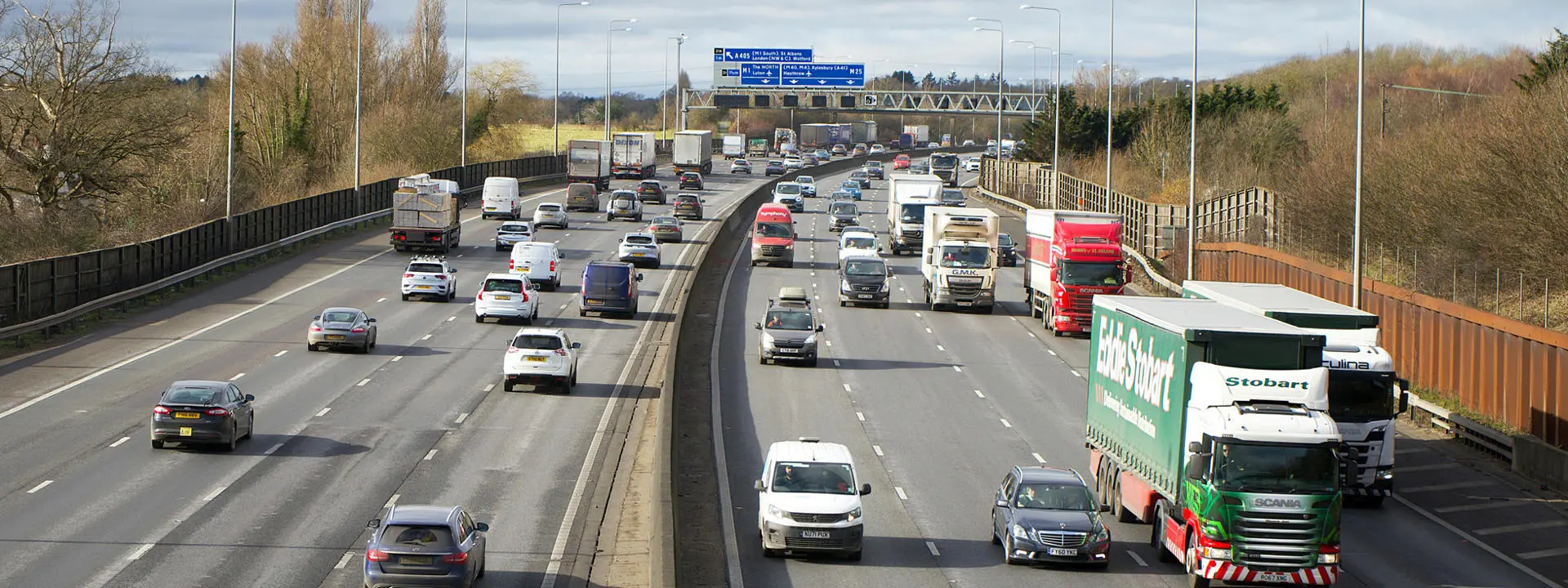 Cars and trucks on a busy motorway. Photo by Mike Bird on Pexels.
