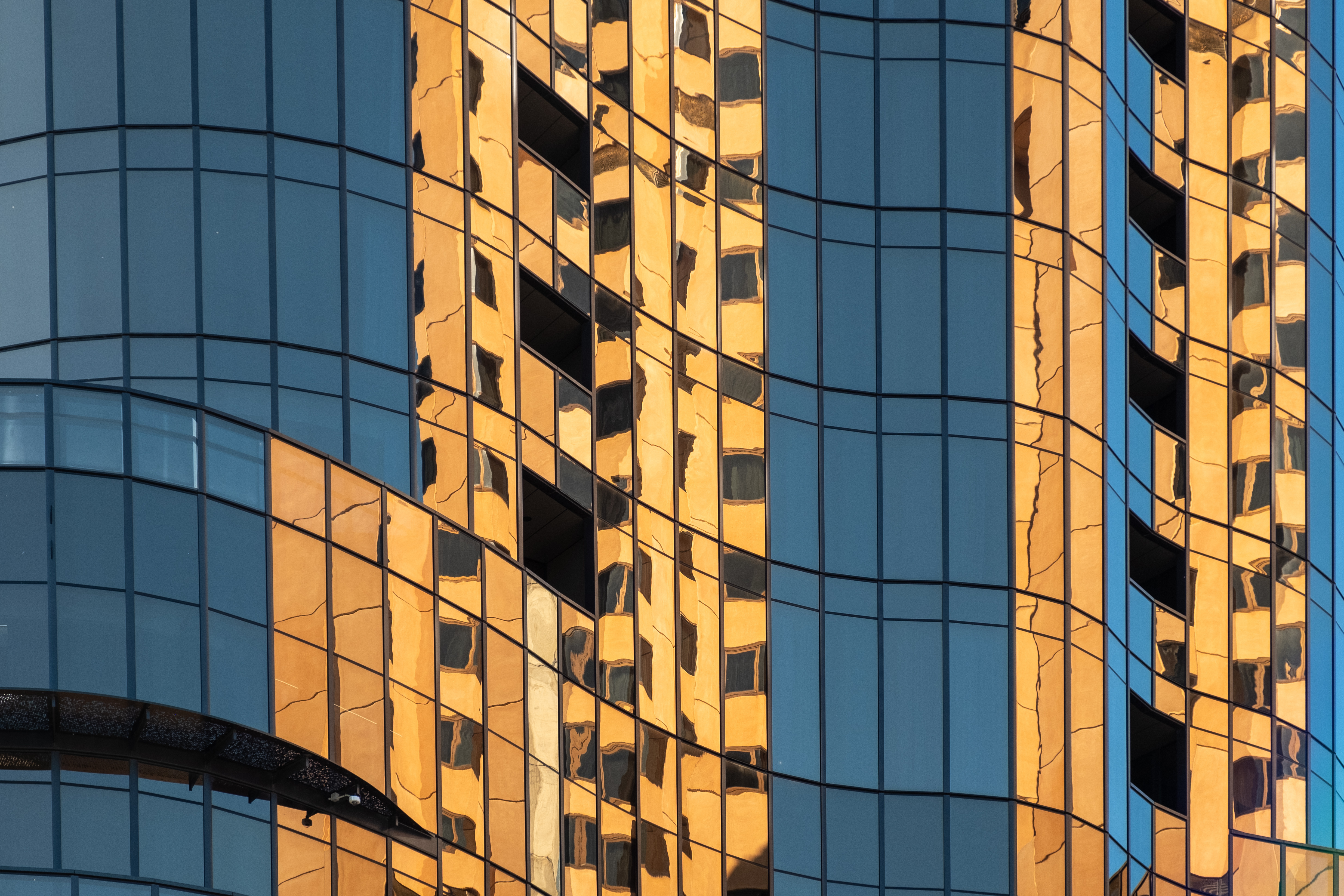 Skyscraper buildings with orange reflected in windows.