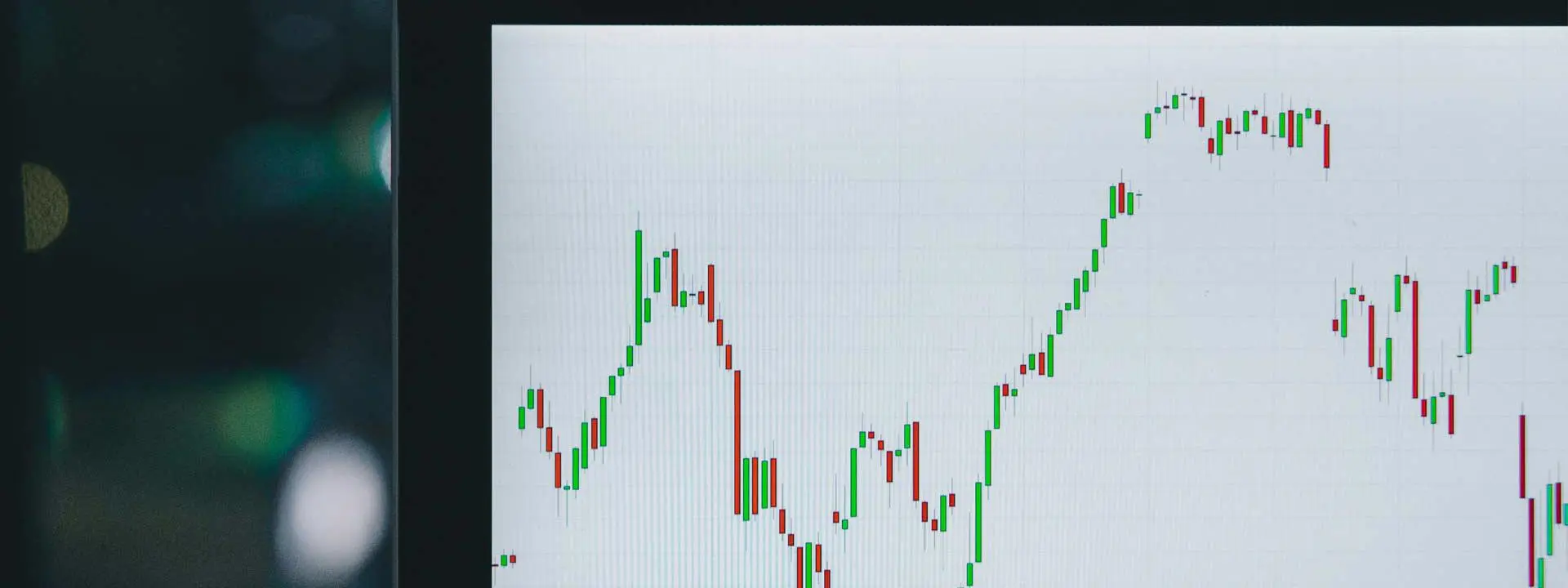 A laptop screen displaying a stock chart with fluctuating lines and data points.