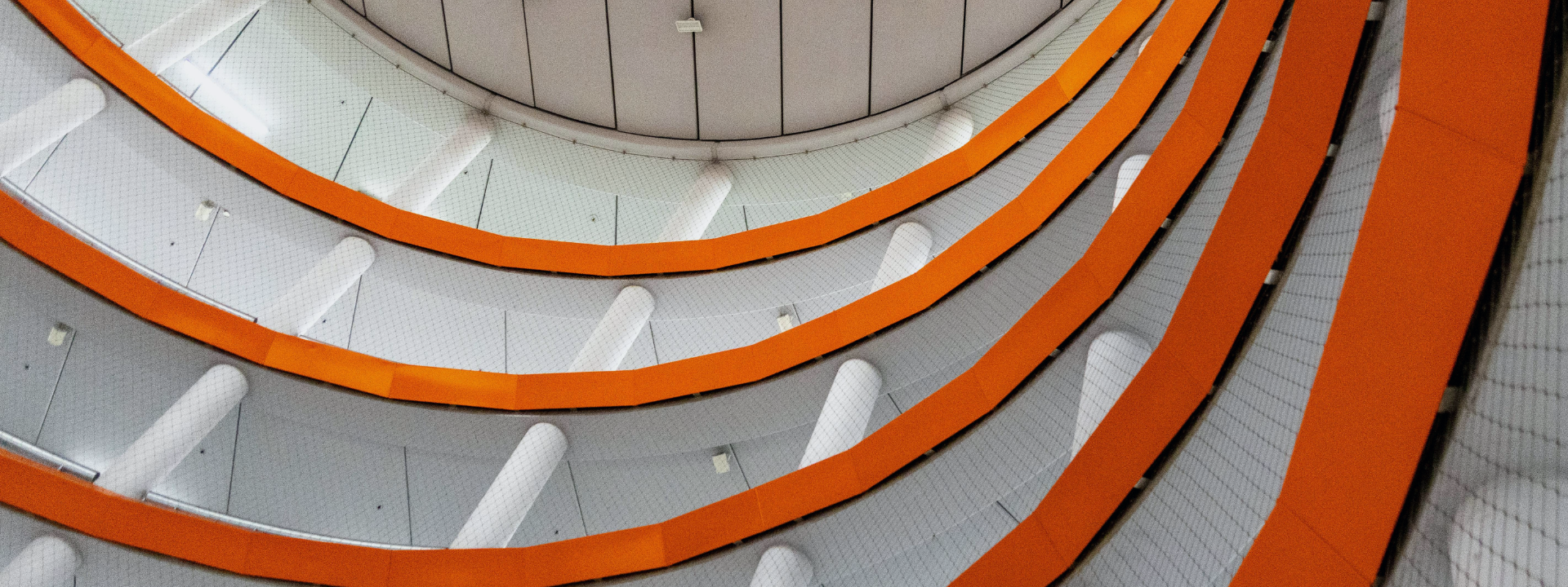 Looking up at an orange spiral staircase.