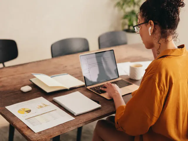 Women works on laptop at home desk