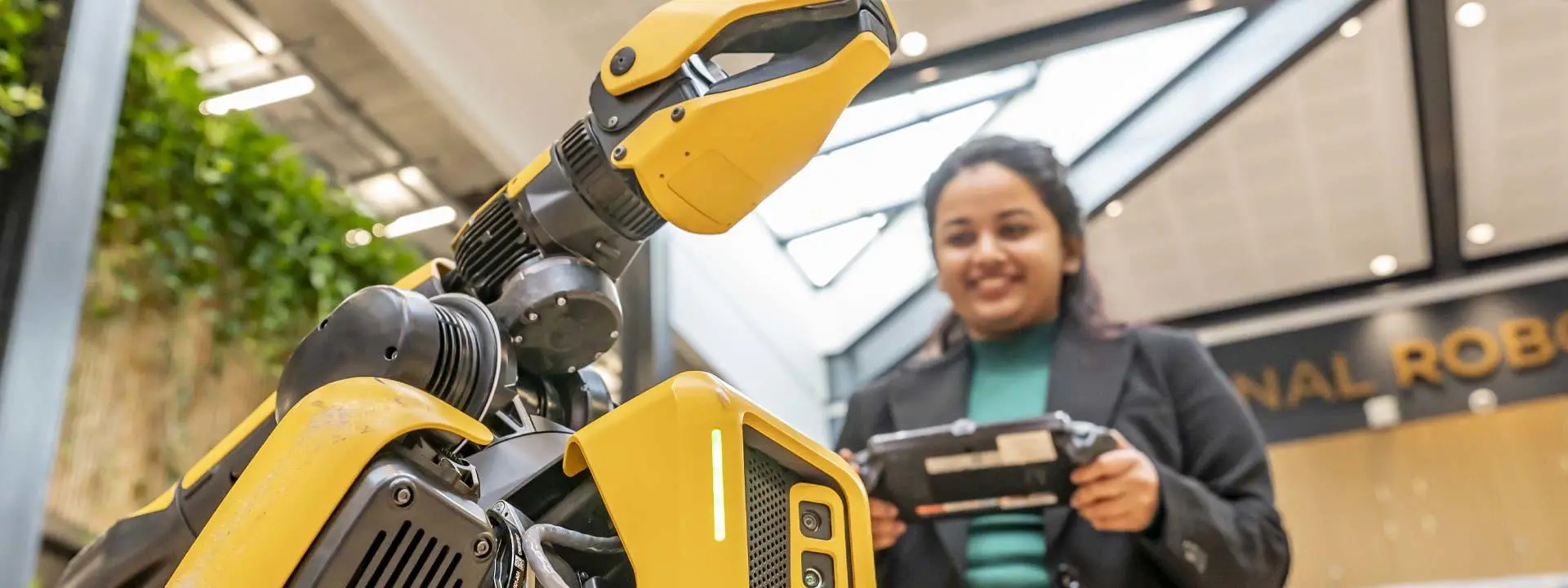 A student controls a yellow and black robot