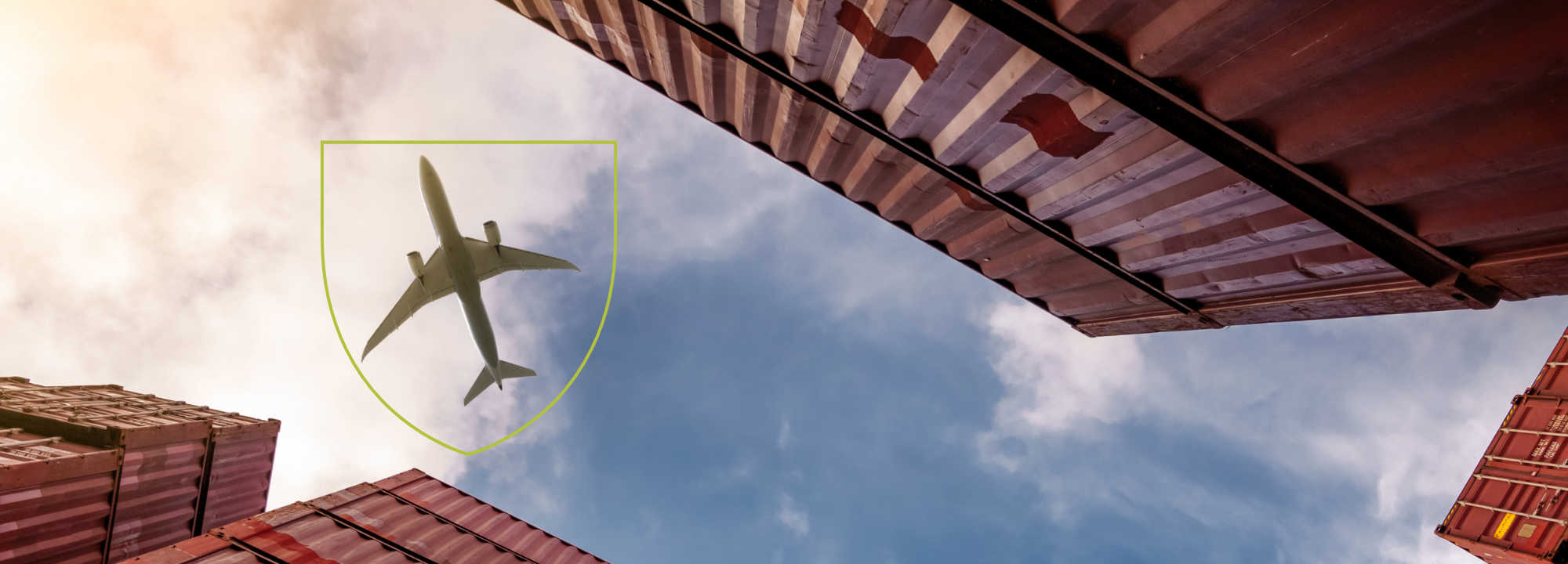 Plane flies over shipping containers.