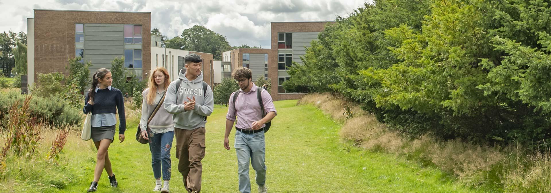 Students chatting as they walk through the campus grounds.