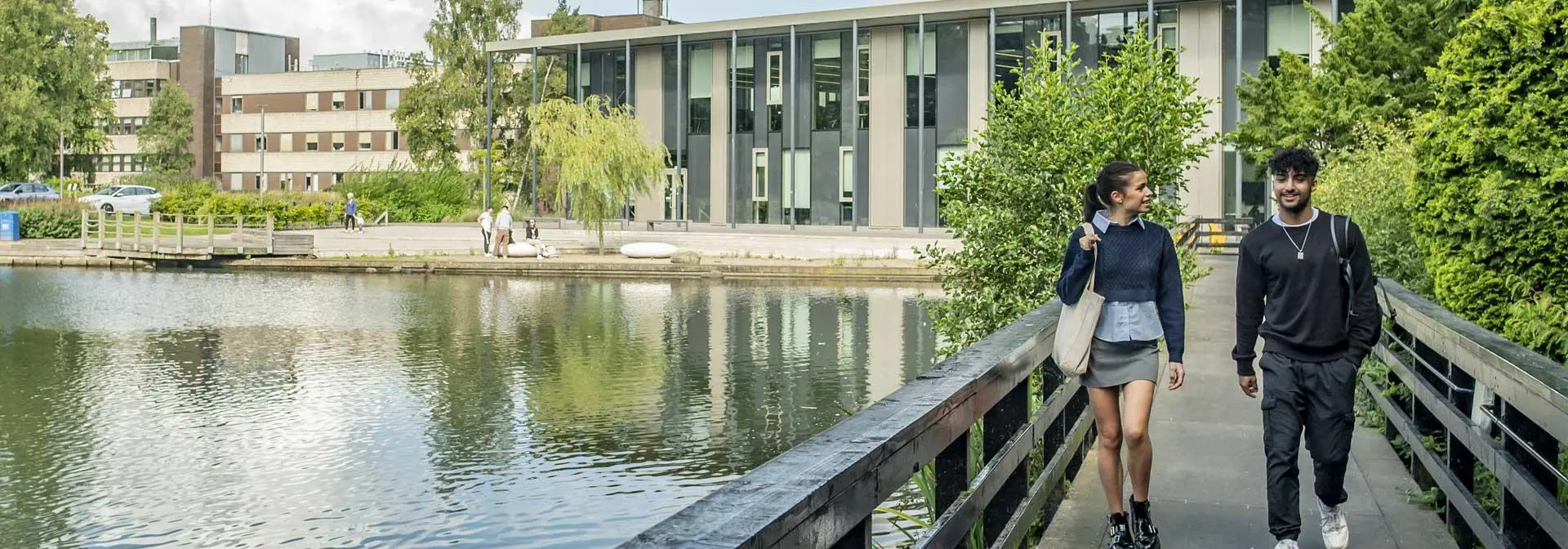 Students walking across bridge on loch