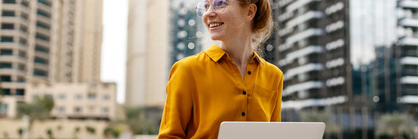 A woman sits with a laptop in Dubai