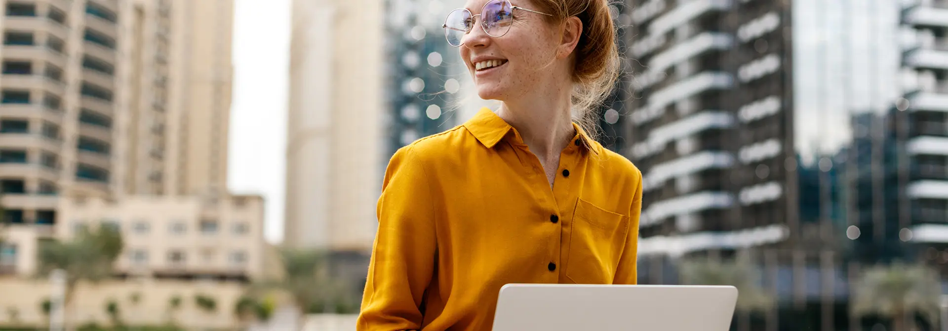 A woman sits with a laptop in Dubai