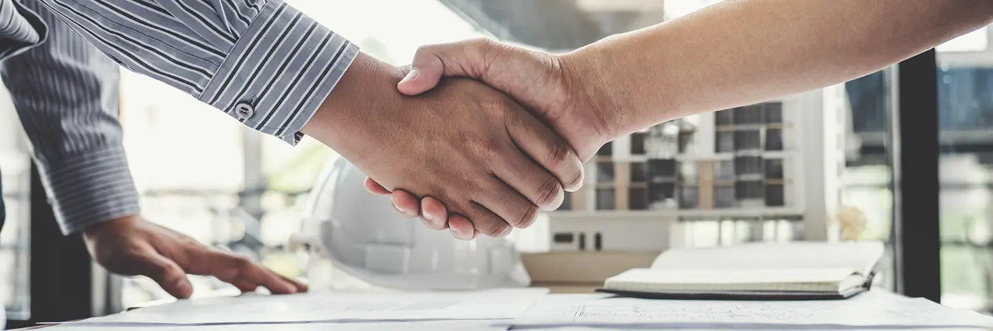 Two workers in industry shaking hands