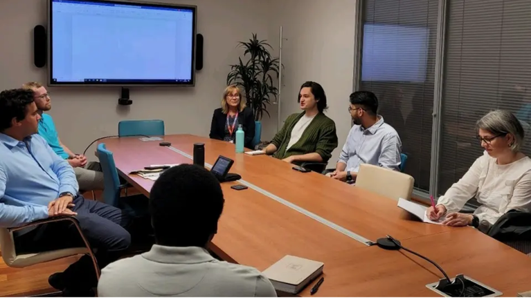Meeting room full of people in deep discussion.