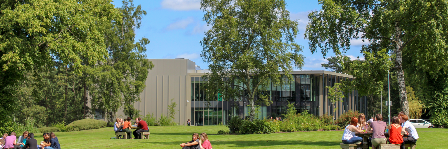 Staff and students sitting out on the lawn on a sunny day at our Edinburgh campus.
