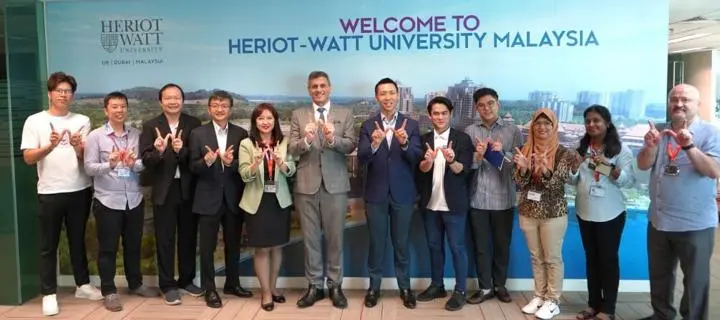 Heriot-Watt University Malaysia employees holding up fingers to make a letter 'W'