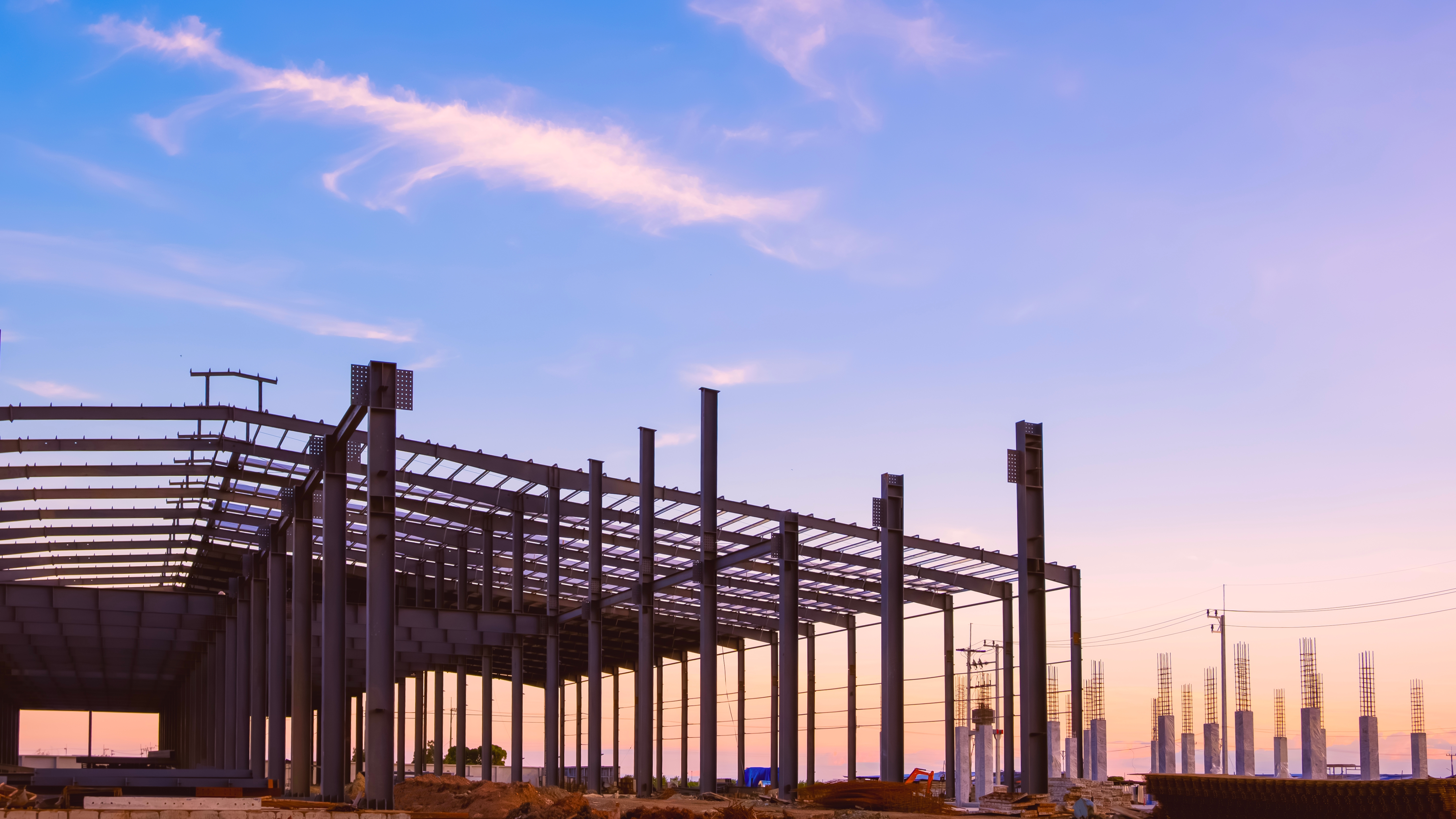 metal frame of a building against a sunset sky