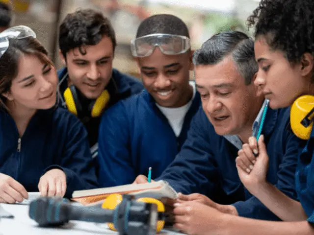Students wearing safety googles talking with business person