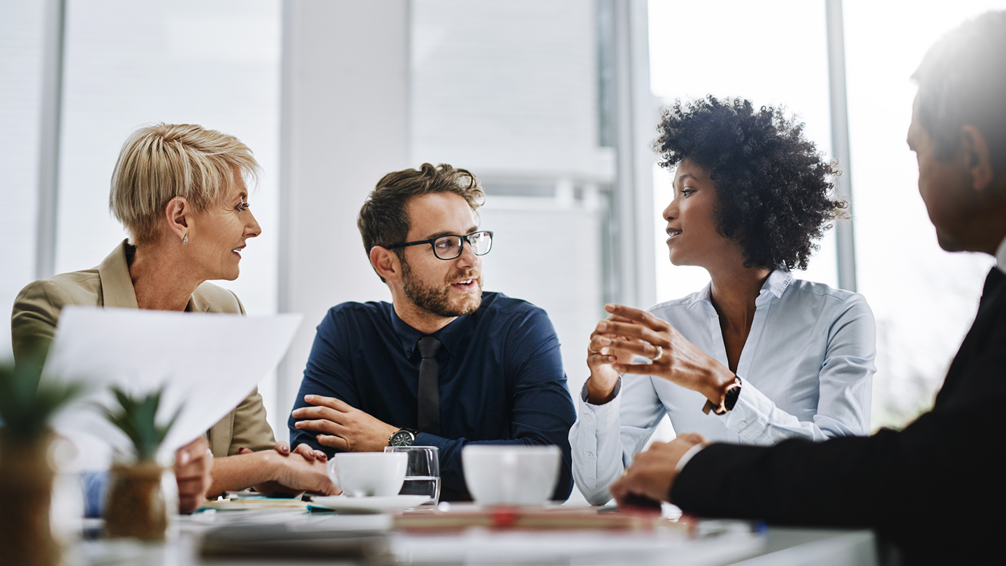 Four business people having a meeting over coffee.