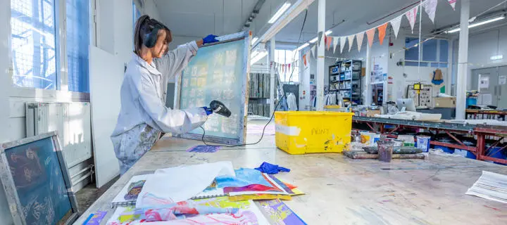 An individual with a canvas dries wet paint in an art room at our Scottish Borders campus.