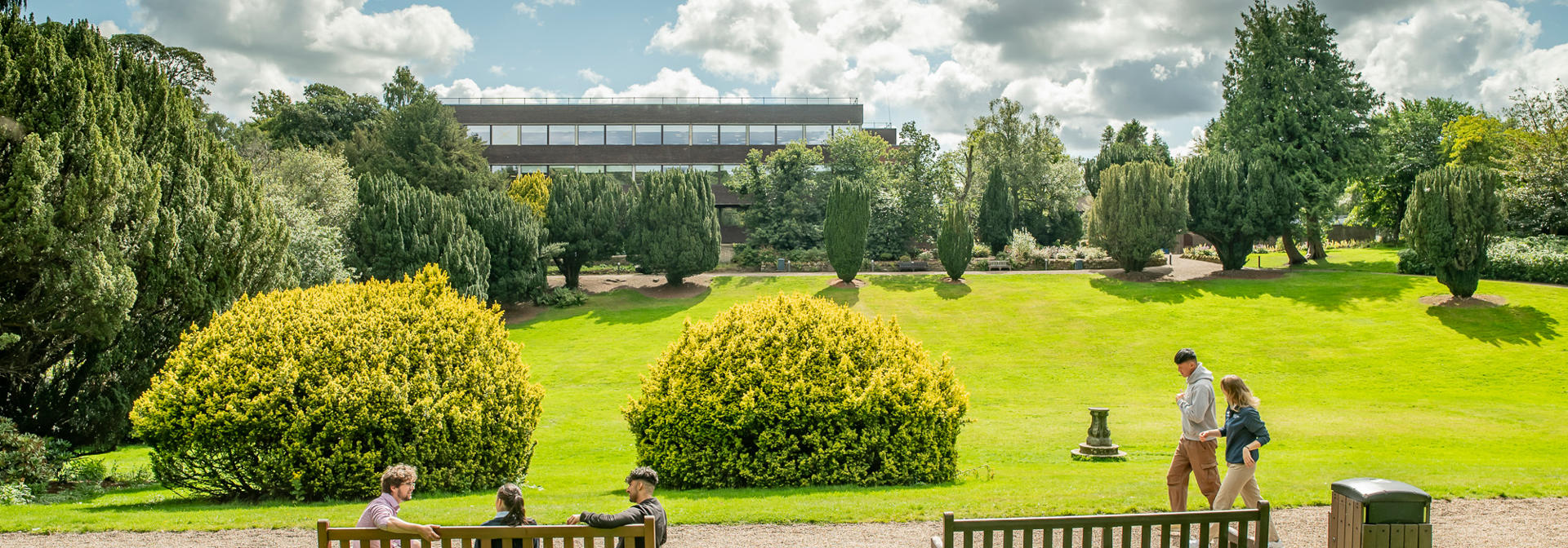 Students walking across the campus grounds and chatting on a sunny day