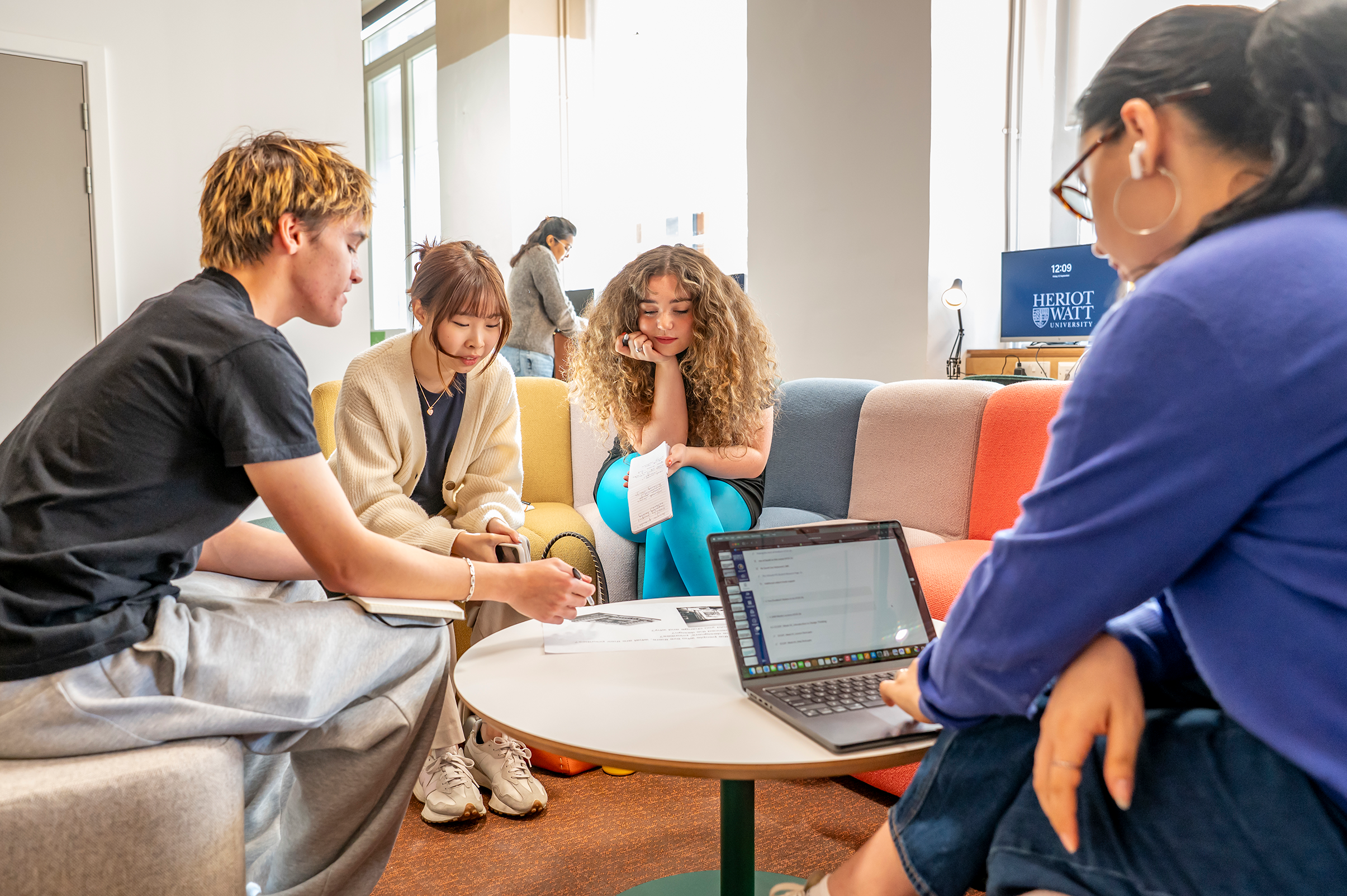 Four students working around a small round table