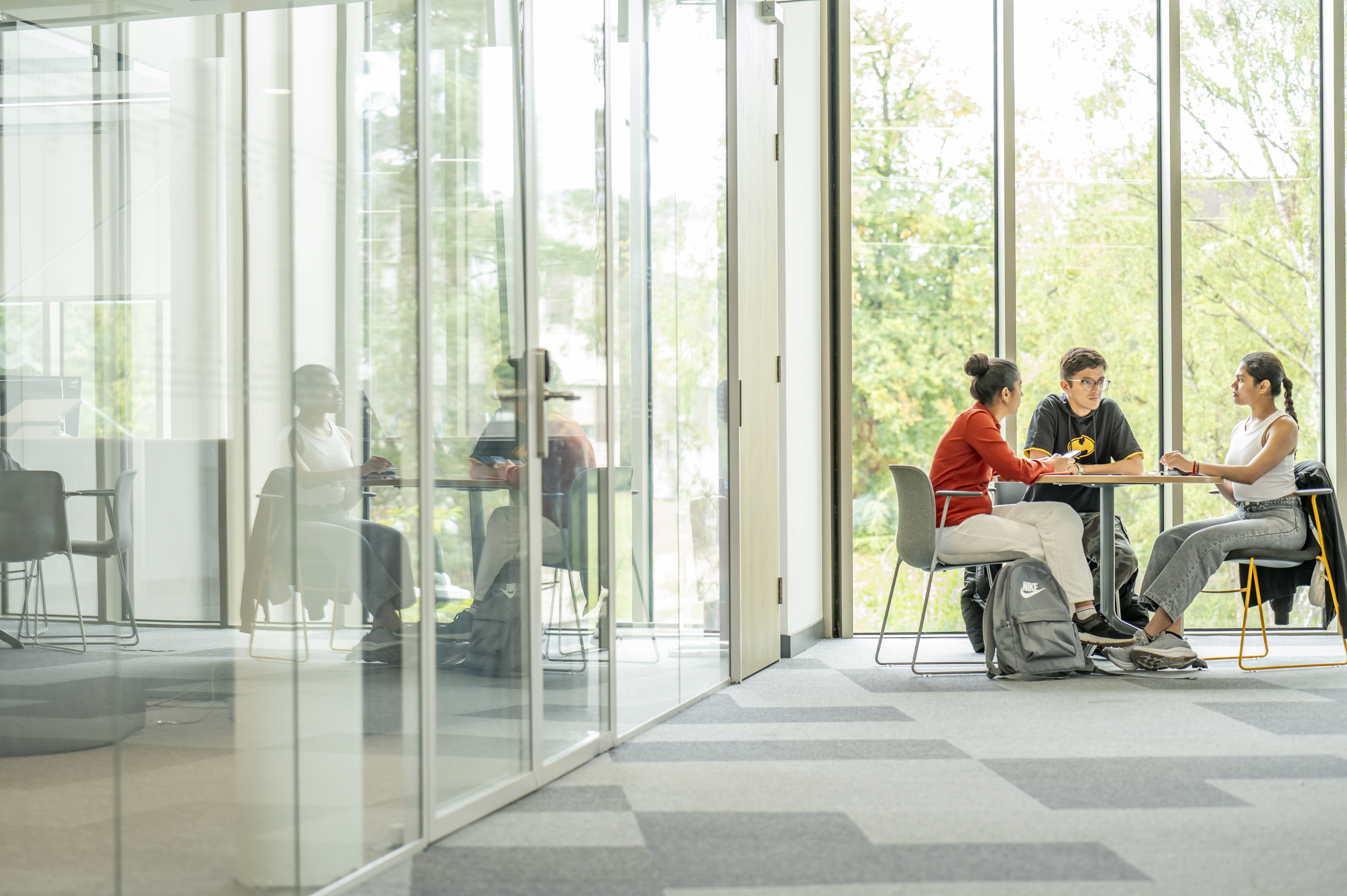 Three students working together at a table in GRID