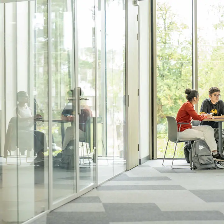 Three students working together at a table in GRID