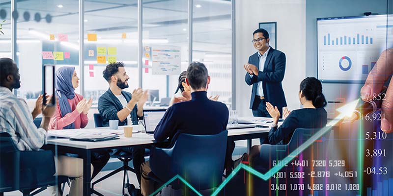 A group of business people sit and applaud in a meeting room