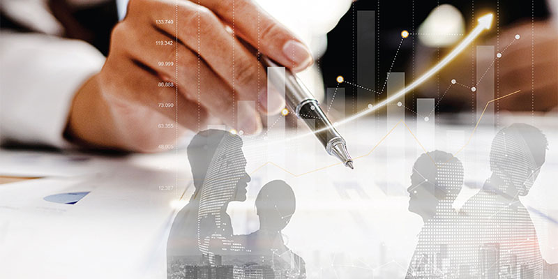 A business man's hand holding a pen alongside resource chart and images 