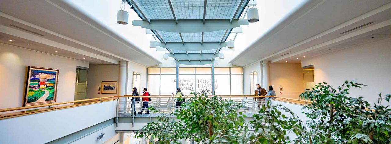 Students cross the walkway in the Edinburgh Business School