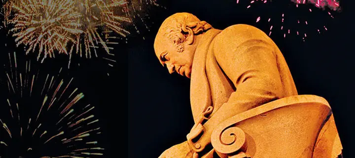 low shot of James Watt statue with fireworks in the background