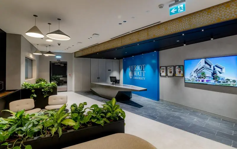 modern stone color reception desk in front of blue wall with a HW logo