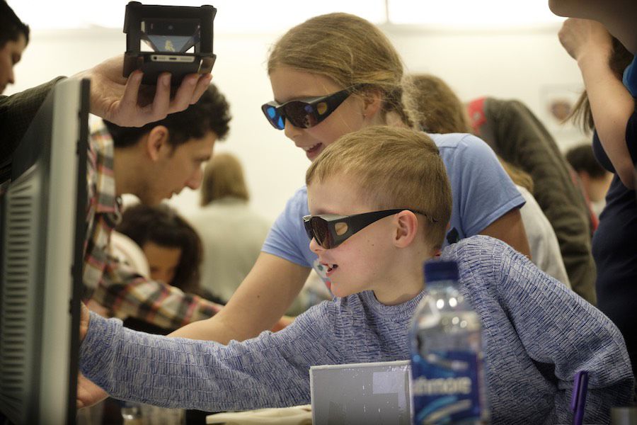 Children with protective glasss looking at lasers