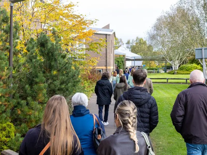 Individuals walking towards an event on Edinburgh campus